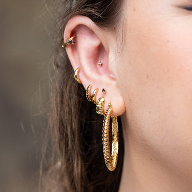 Huggie earrings worn in upper lobe cartilage piercing