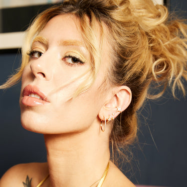 Starburst Gold Huggie Earrings with Clear Stones on Model