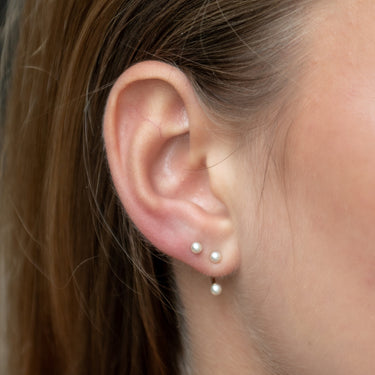 Woman Wearing Pearl Ear Jacket Stud Earrings in 18ct Gold Plated Sterling Silver