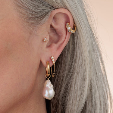 Pearl huggie earrings worn in helix piercing