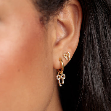 sparkling bow stud earrings for lobe piercings shown on model