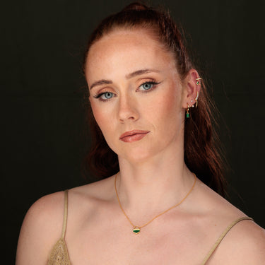 Woman Wearing Gold Emerald Green Art Deco Pendant Necklace with Green & Pearl Ear Stack