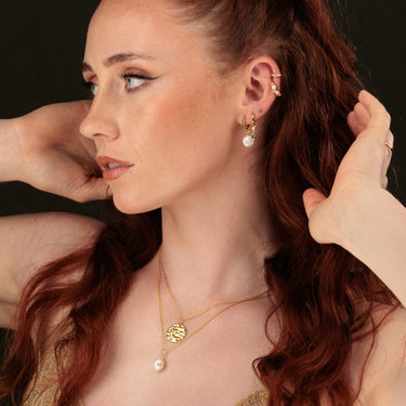Woman Wearing Gold Baroque Pearl Necklace with Moon Phase Pendant