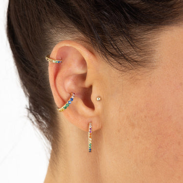 Gold Huggie Earrings with Rainbow Stones On Model's helix piercing