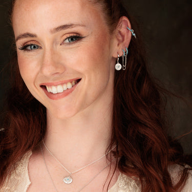 Woman Wearing Silver Turquoise Double Huggie Earring with Twin Chain Connector in Ear Stack