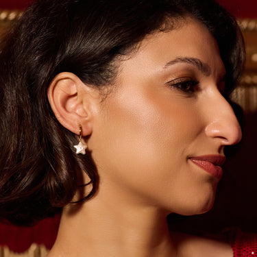 Woman Wearing Gold Pearl Star Charm Hoop Earrings
