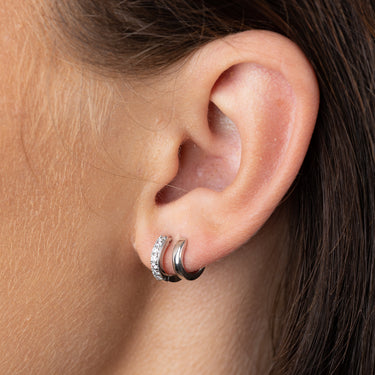 Mismatched Double Silver Huggie Earrings with Clear Stones on ear