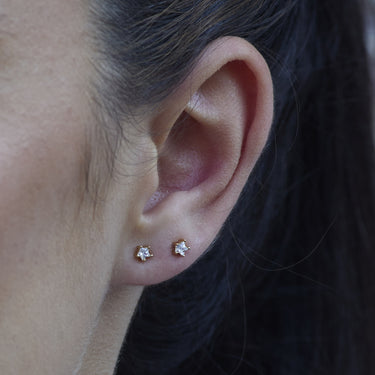 Woman Wearing Gold Sparkling Star Stud Earrings | Star-Shaped Clear Stone Stud Earrings