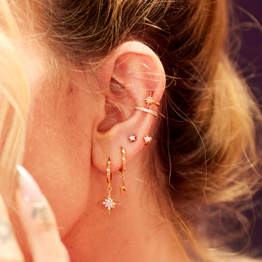 gold celestial ear stack with gold lightning bolt charm hoops in second lobe ear piercing