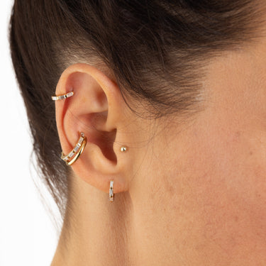 Baguette huggie earrings worn in helix and lobe piercing on model