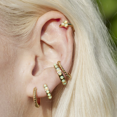 Twisted hoop earring shown in lobe and conch piercing on ear