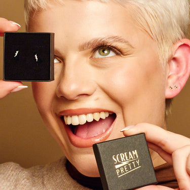 Woman Holding Gold Dainty Lightning Bolt Stud Earrings | Lightning Shaped Studs