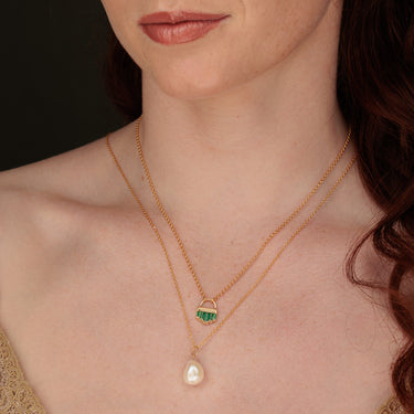 Woman Wearing Gold Emerald Green Art Deco Pendant Necklace & Baroque Pearl Necklace