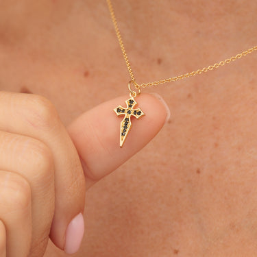 Gold Cross Pendant Necklace with Black Nano Stones Held in Hands
