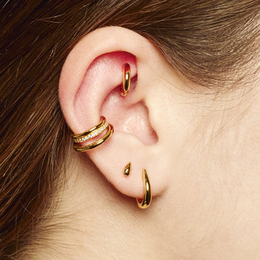 Gold Claw Huggie Earrings on ear lobe perfect for all cartilage piercings