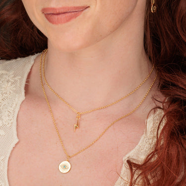 Woman Wearing Gold Evil Eye and Lightning Bolt Necklaces