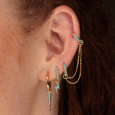 Woman Wearing Gold Turquoise Double Huggie Earring with Twin Chain Connector in Turquoise Ear Stack