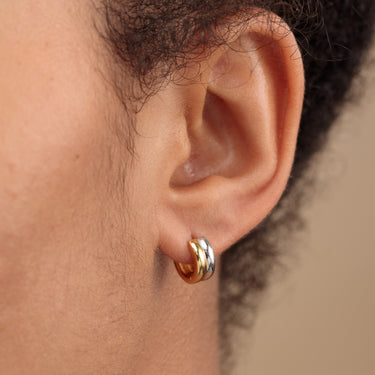 Mixed Metal Silver & Gold Huggie Earrings on lobe piercing on model ear 