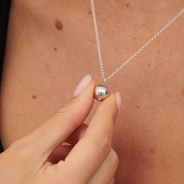 Silver Disco Ball Charm Necklace Held in Hand