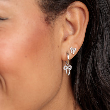 silver sparkling Bow charm hoop earrings perfect for lobe piercings shown on model