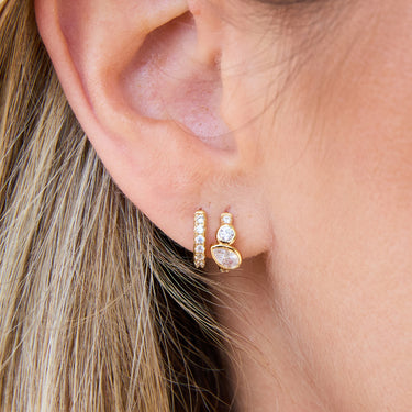 Close-up of Gold Toi Et Moi Huggie Earrings with Clear Stone Huggies