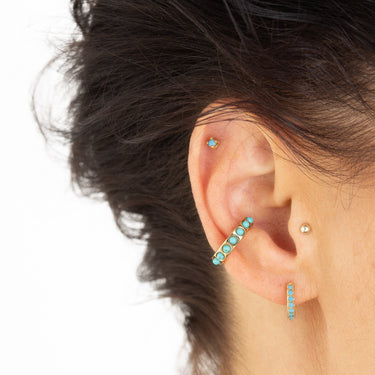 Turquoise huggie earring shown in lobe piercing on ear. Also perfect for all other cartilage piercings including helix piercing 