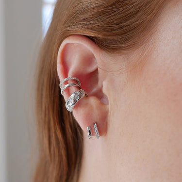 Mismatched Double Silver Huggie Earrings with Clear Stones on ear 