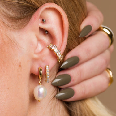 Pearl ear stack with multiple piercings. Large huggie earring in second lobe piercing