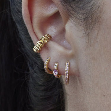 Gold Huggie Earrings with Pink Stones on ear