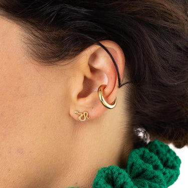 Woman Wearing Gold Snake Stud Earrings with Green Stones | Serpent Shaped Studs